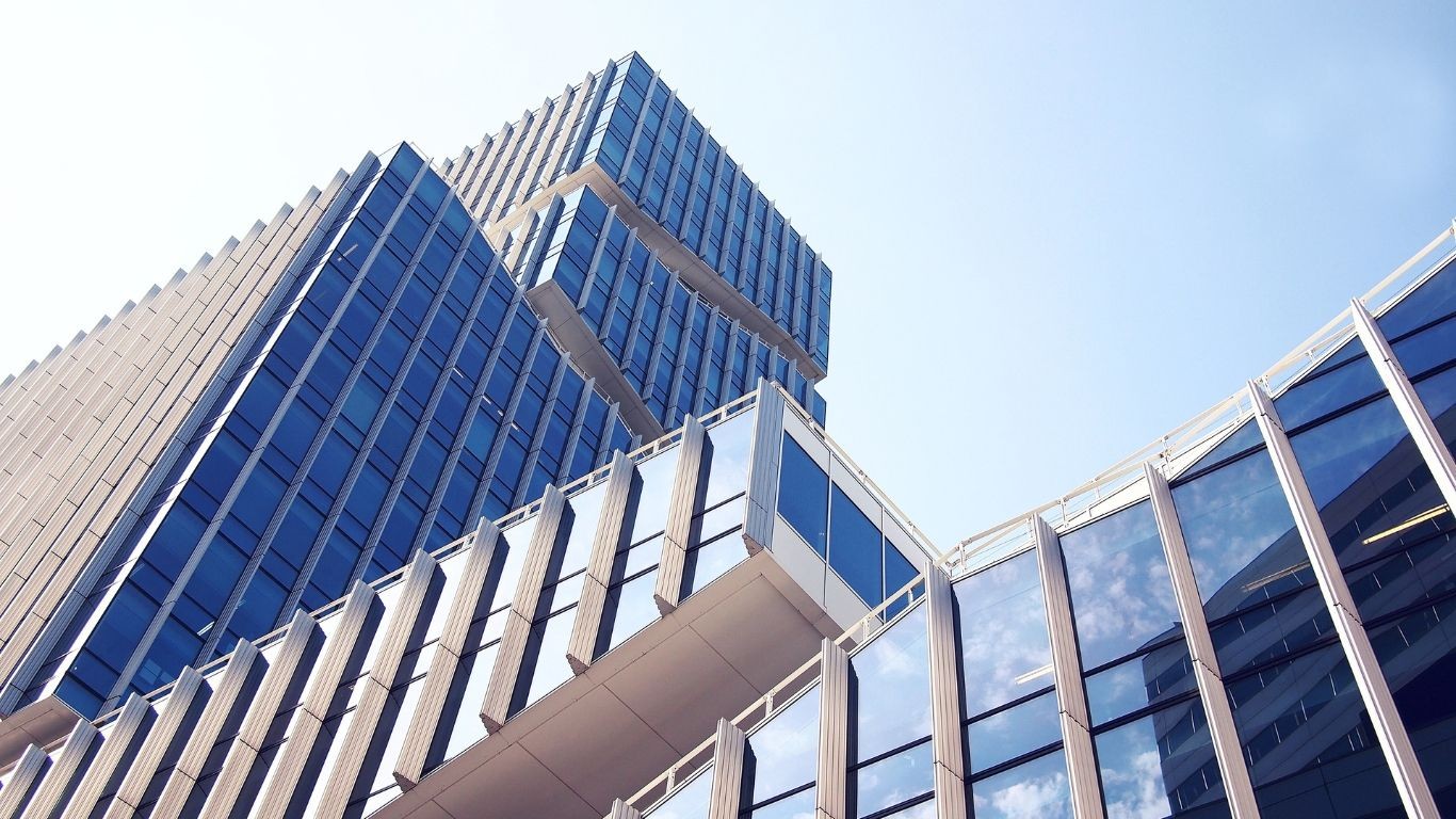 Modern skyscraper with reflective glass windows against a clear blue sky.